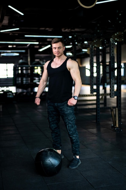 Jonge lifestyle bodybuilder Gespierde sterke man aan het trainen in de sportschool