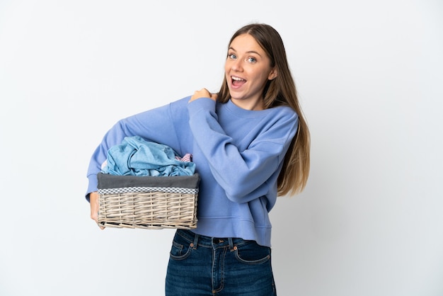 Jonge Litouwse vrouw die een wasmand houdt die op witte achtergrond wordt geïsoleerd die een overwinning viert