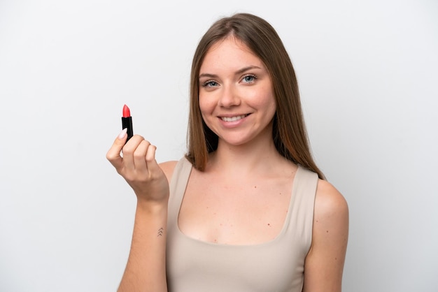Jonge Litouwse vrouw die op witte achtergrond wordt geïsoleerd die rode lippenstift houdt