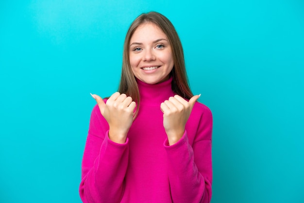 Jonge Litouwse vrouw geïsoleerd op blauwe achtergrond met duim omhoog gebaar en lachend