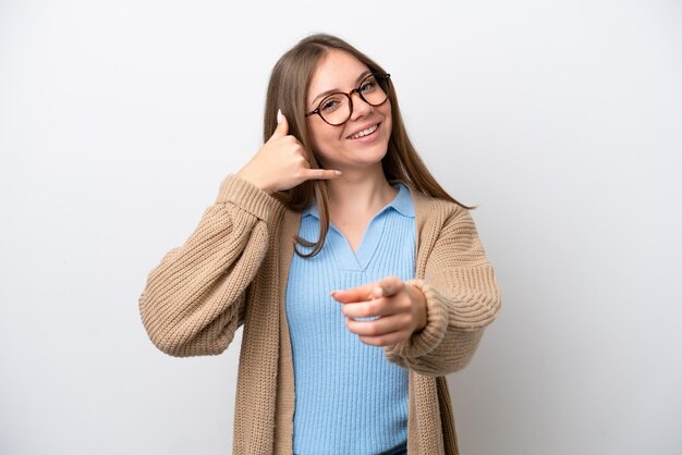 Jonge Litouwse vrouw geïsoleerd op een witte achtergrond die een telefoongebaar maakt en naar voren wijst