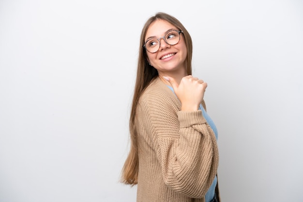 Jonge Litouwse vrouw geïsoleerd op een witte achtergrond die naar de zijkant wijst om een product te presenteren