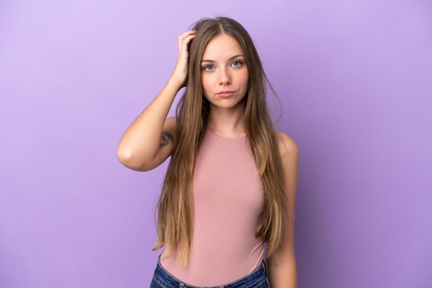 Jonge Litouwse vrouw geïsoleerd op paarse achtergrond met een uitdrukking van frustratie en niet begrip