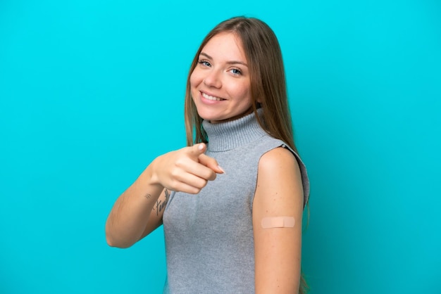 Jonge Litouwse vrouw met pleisters geïsoleerd op een blauwe achtergrond wijst de vinger naar je met een zelfverzekerde uitdrukking