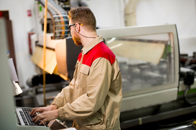 Jonge man aan het werk in de fabriek