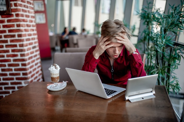 Jonge man aan het werk in een café benadrukt