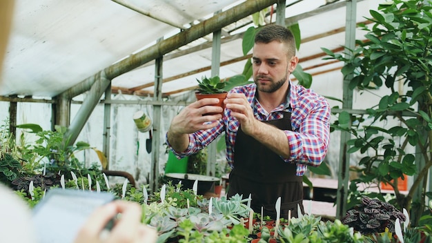 Jonge man aan het werk in tuincentrum