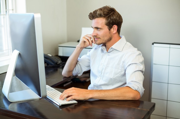 Jonge man aan het werk op computer bureau