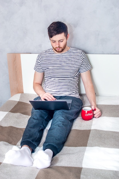 Jonge man aan het werk op een laptop