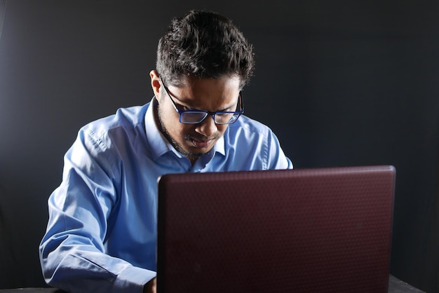 Jonge man aan het werk op laptop die persoonlijke gegevens steelt