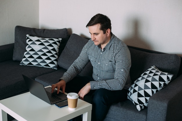 Jonge man aan het werk op zijn computer vanuit huis