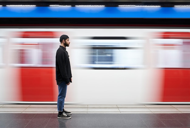 Jonge man aan zijn zijde met een masker op het metroplatform