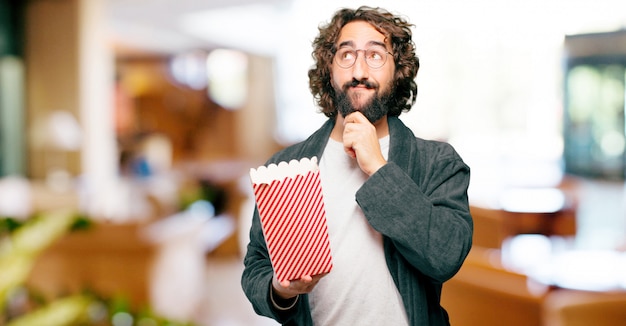 Jonge man badjas nacht pak met popcorns emmer te dragen