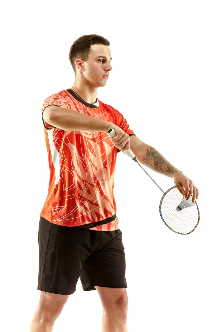 Foto jonge man badminton spelen over witte studio achtergrond. fit mannelijke atleet geïsoleerd op wit. badmintonspeler in actie, beweging, beweging. aanvals- en verdedigingsconcept