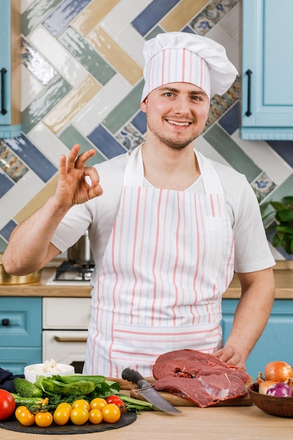 Jonge man bereidt eten thuis in de keuken.