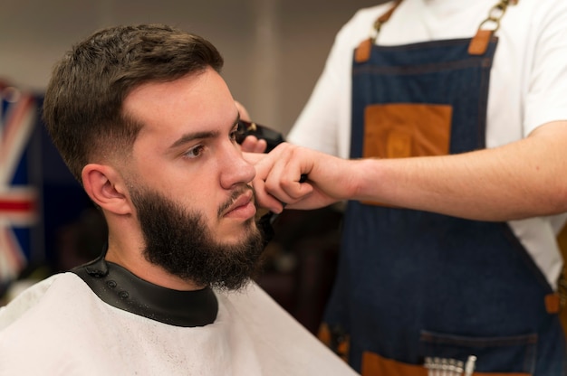 Foto jonge man bij de kapper wordt geknipt