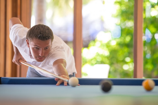 Jonge man biljart spelen op zomervakantie