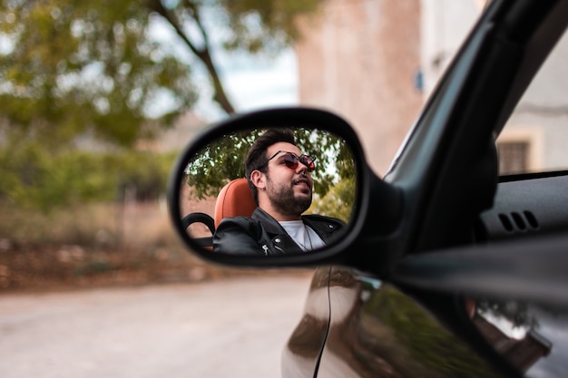 Jonge man converteerbare auto rijden.