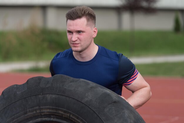 Jonge man die band omdraait - Bodybuilding oefeningen vrachtwagenband