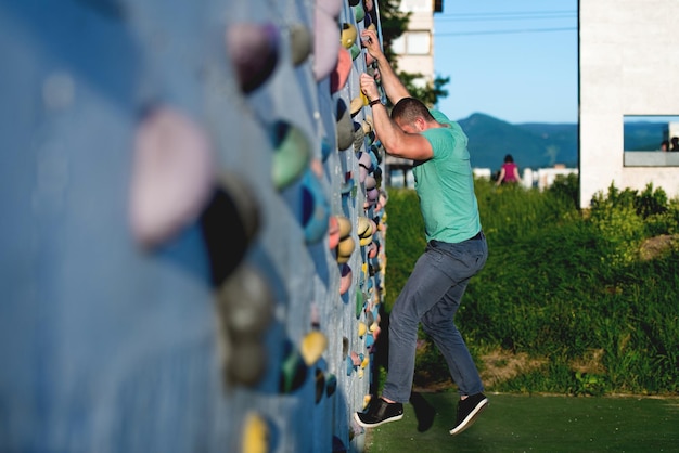 Foto jonge man die buiten op de muur klimt