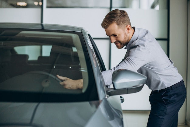 Jonge man die een auto kiest in een autosalon