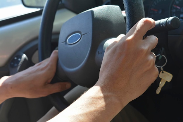 jonge man die een auto rijdt met de sleutels in het stuur