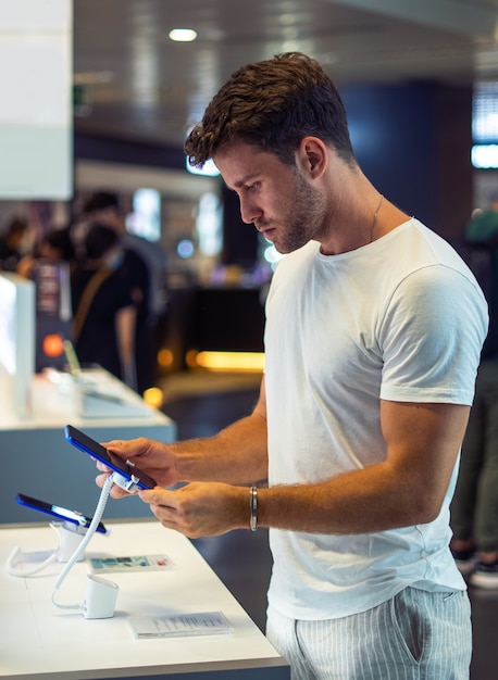 Jonge man die gadget in de winkel koopt