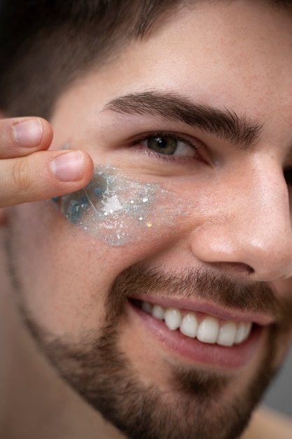 Foto jonge man die glanzende lotion op haar gezicht aanbrengt