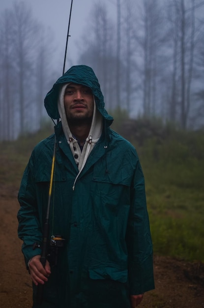 Foto jonge man die in de winter in het bos staat