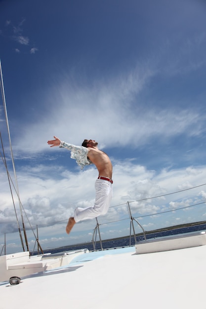 Jonge man die met zijn boot op de open oceaan vaart