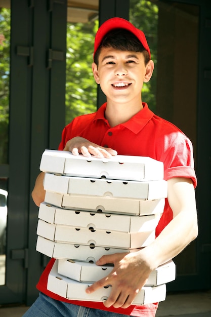 Jonge man die pizzadoos levert in de buurt van huis