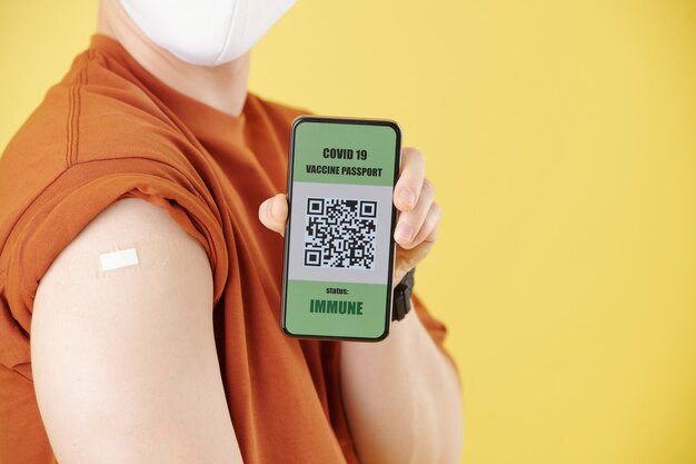 Jonge man die smartphone met qr-code laat zien na vaccinatie tegen coronavirus