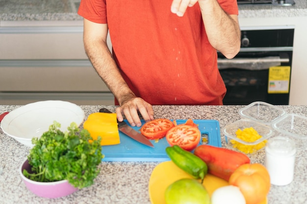 Jonge man die thuis een salade maakt