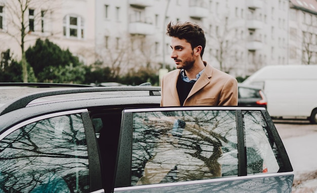 Jonge man die tijdens het regenseizoen in een natte auto in de stad rijdt
