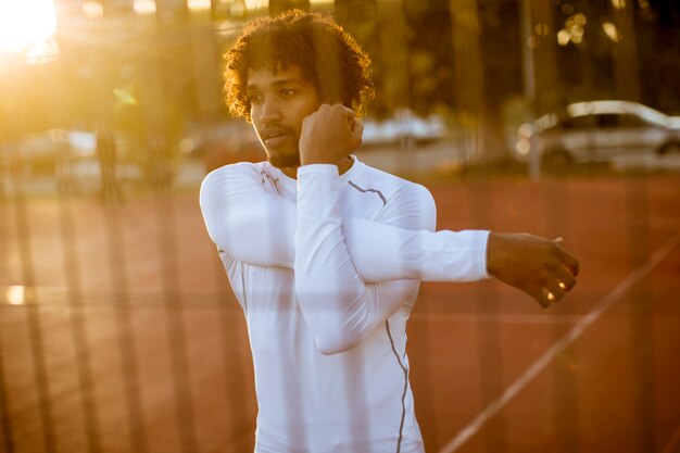 Jonge man die zich uitstrekt tijdens outdoor training