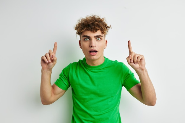 Jonge man die zich voordeed op een witte achtergrond in een groene tshirt