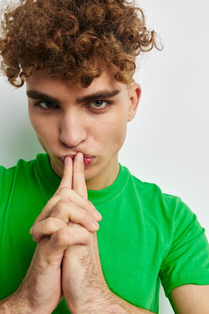 Foto jonge man die zich voordeed op een witte achtergrond in een groene tshirt