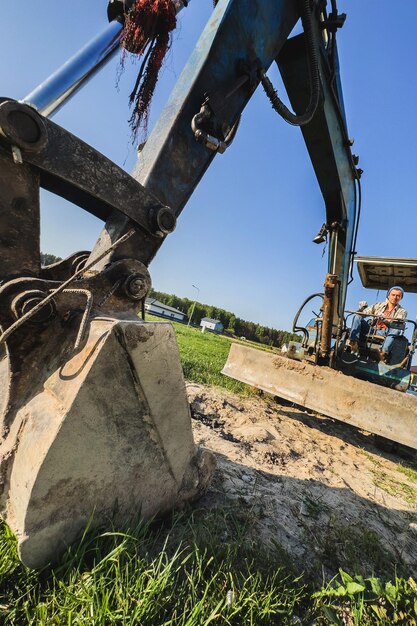 Jonge man die zijn oude graafmachine bedient tijdens zijn werk op een bouwplaats