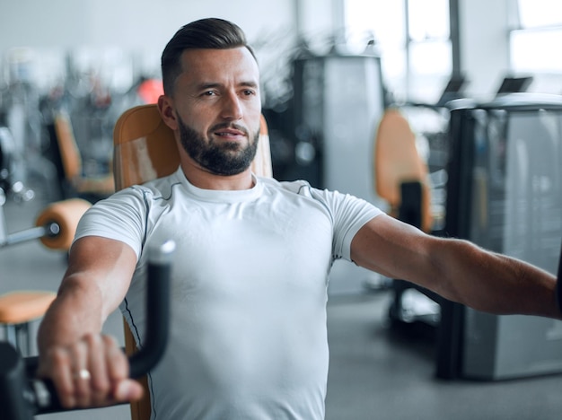 Jonge man doet krachttraining in de sportschool