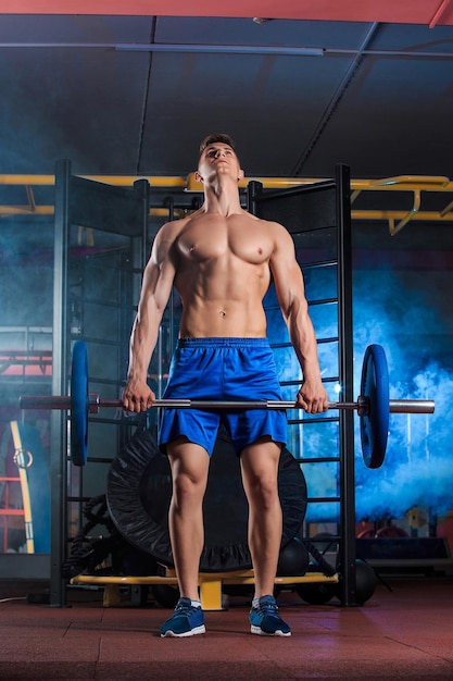 jonge man doet oefeningen met barbell in sportschool