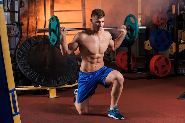 Jonge man doet oefeningen met barbell