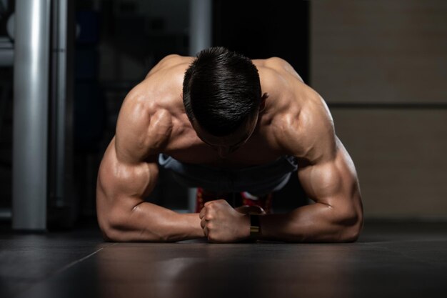 Jonge man doet press-ups in de sportschool