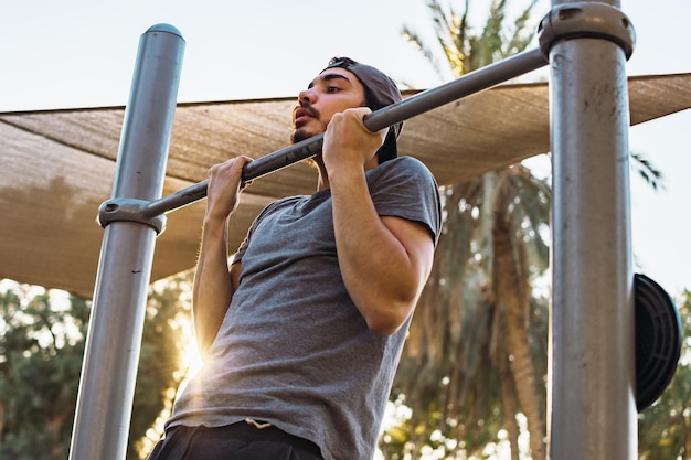 Jonge man doet pull-ups op rekstok