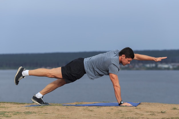 Jonge man doet yoga buiten in natuurlijke omgeving