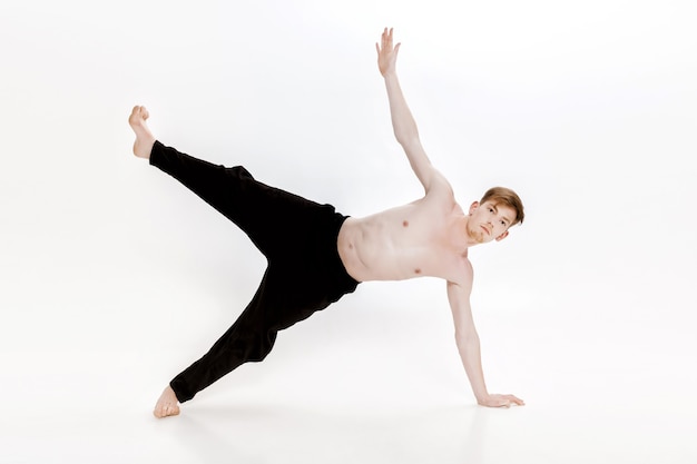 Jonge man doet yoga oefeningen studio opname op witte achtergrond