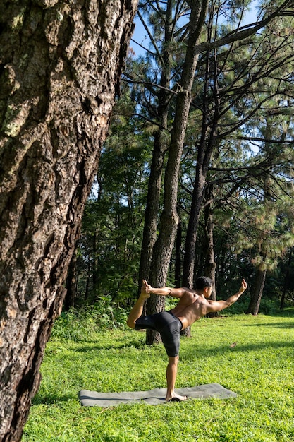 Jonge man doet yoga of reiki in het bos zeer groene vegetatie in mexico guadalajara bosque colomos hispanic