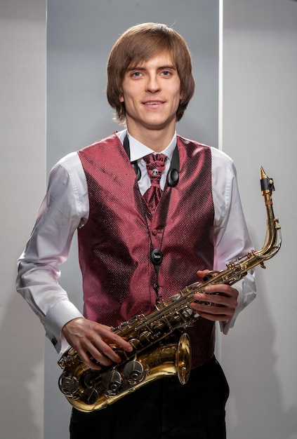 Jonge man draagt een vest met een saxofoon