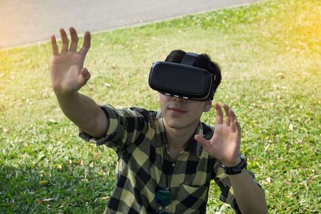 jonge man draagt ​​virtual reality headset in de tuin