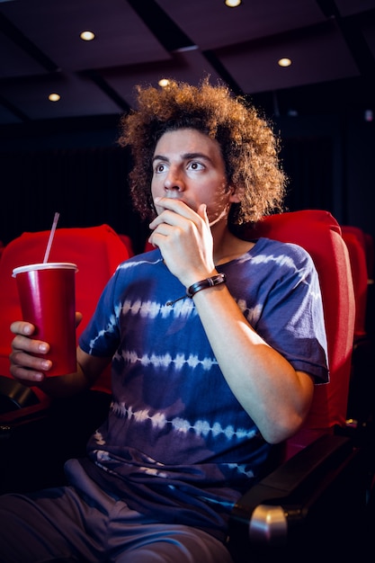 Foto jonge man een film kijken en frisdrank drinken