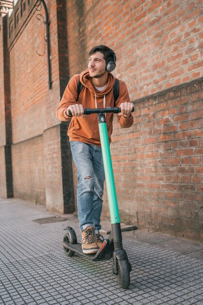 Jonge man elektrische scooter rijden.